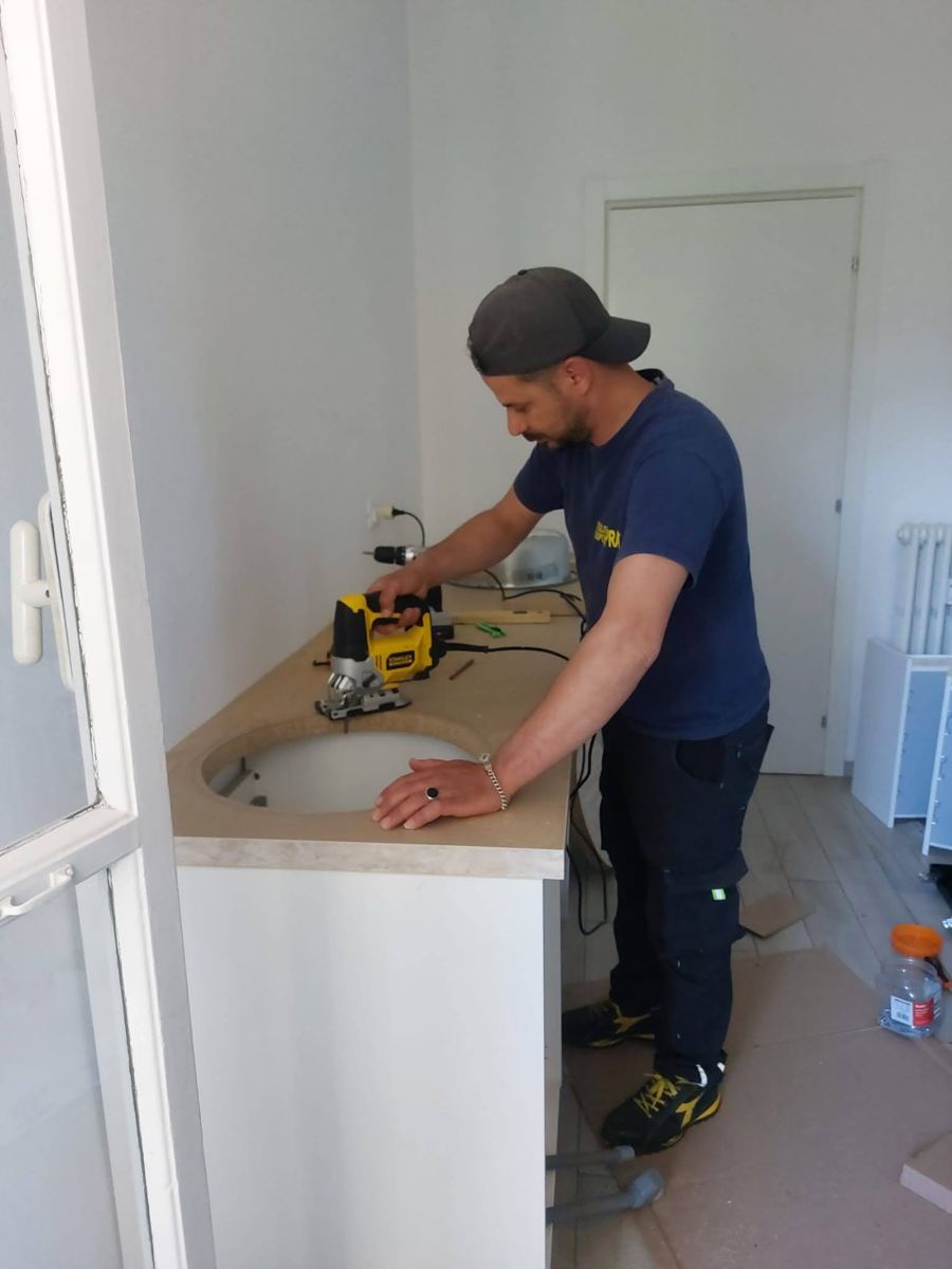 Un operatore di Traslochi Spray monta un mobile nella nuova casa